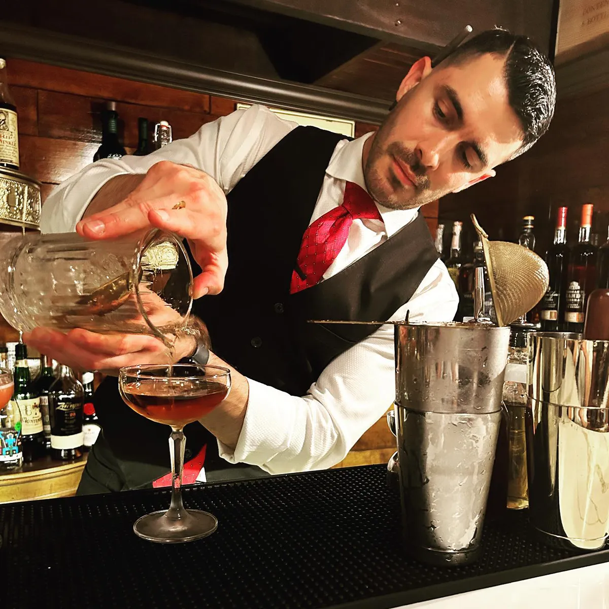A bartender pours a drink at Daniello’s