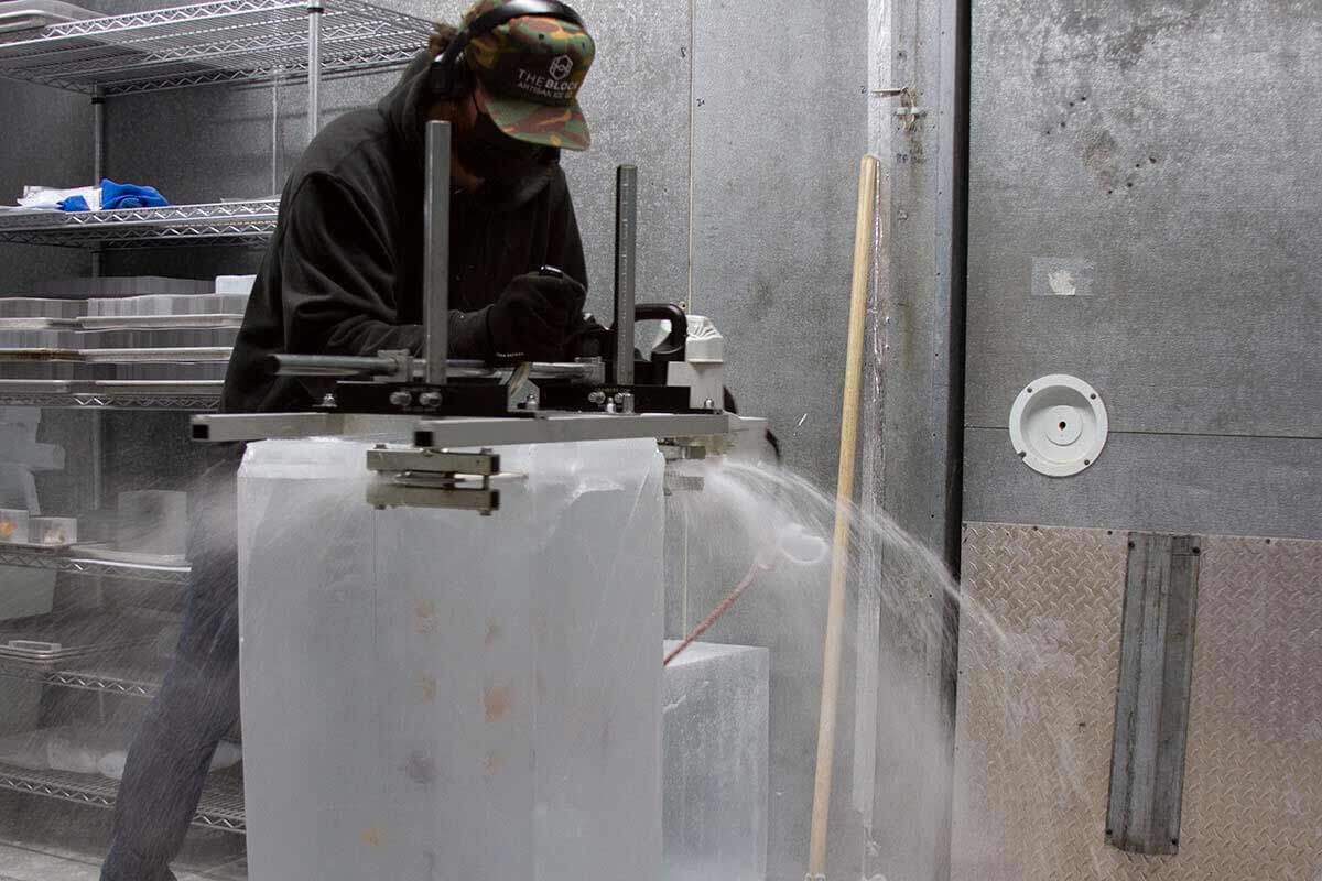 Block Ice founder Matt Briggs cutting craft infused ice cubes.